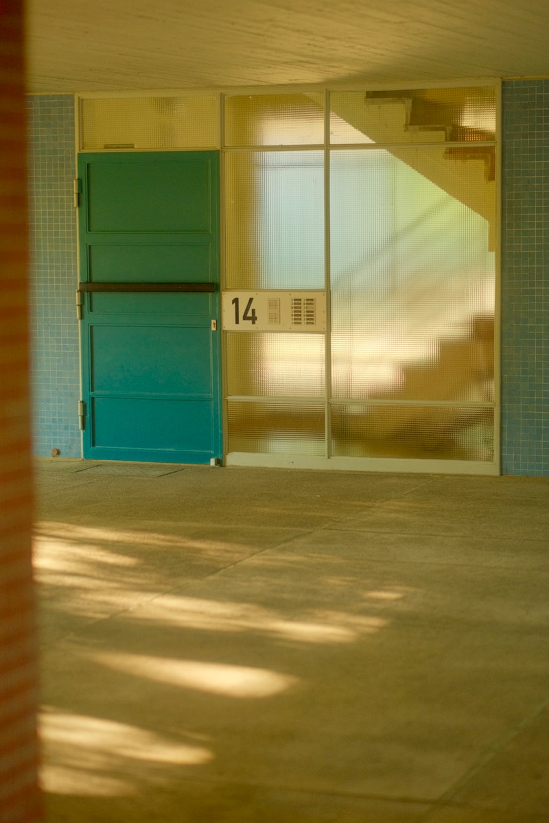 an empty room with a blue door and a red brick wall